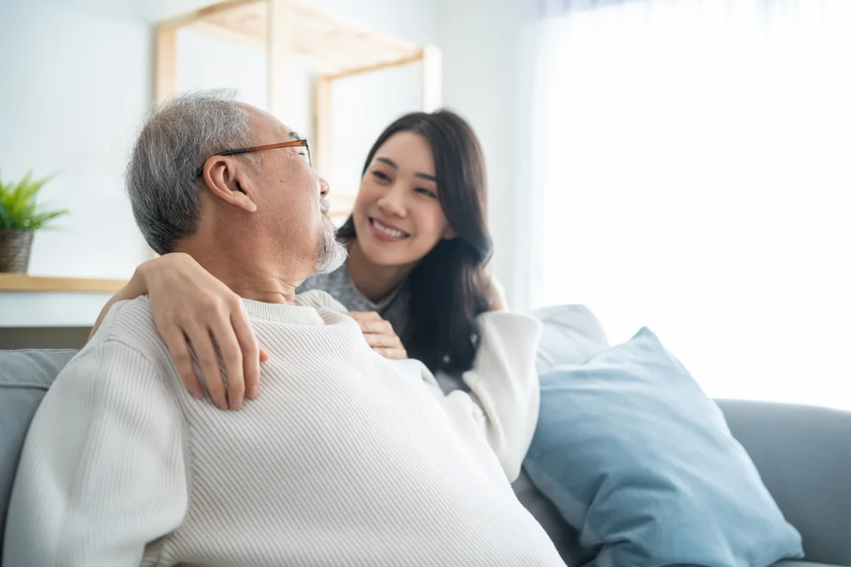 A daughter sharing a warm moment with her father at home