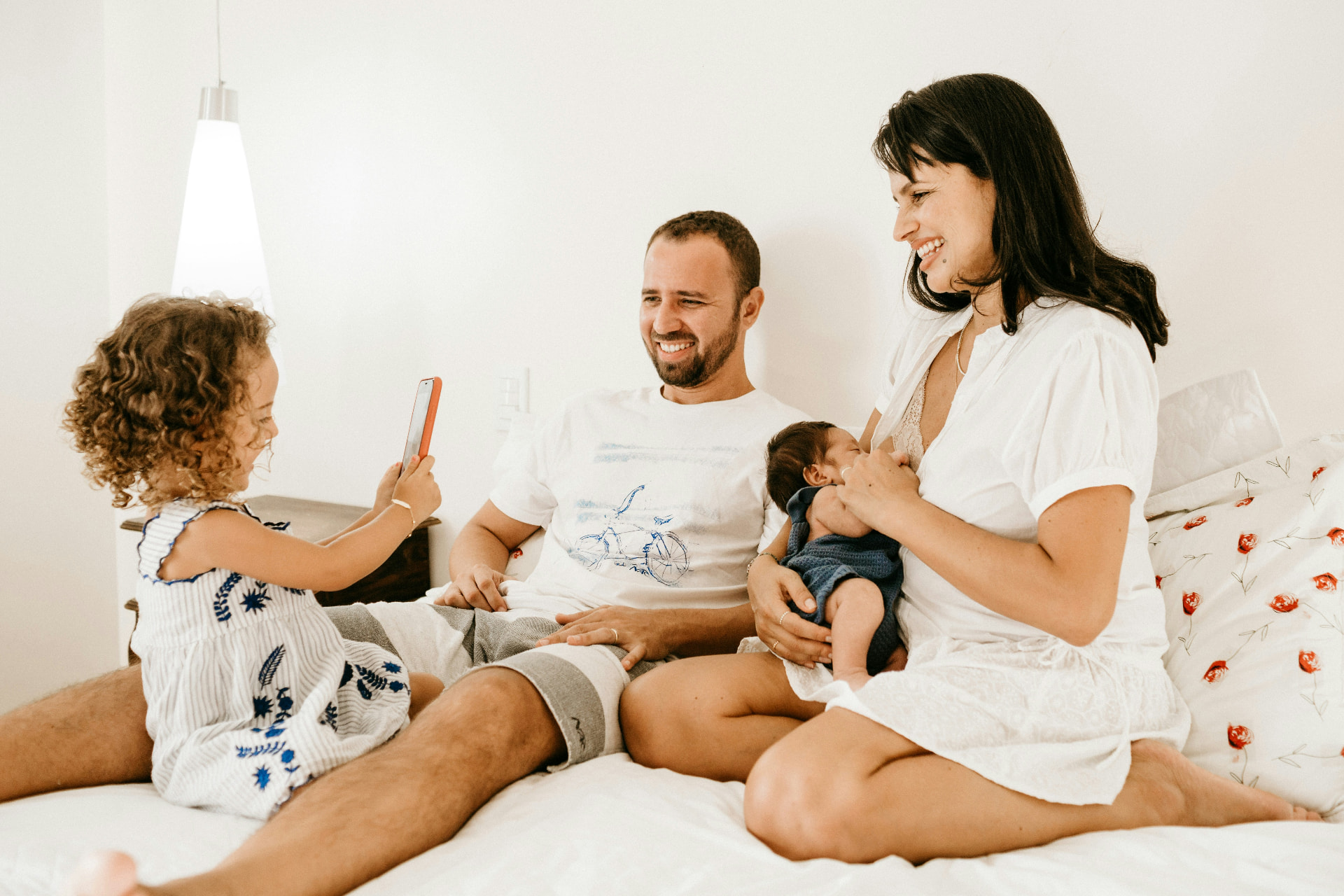 A family sitting together on a bed with their new baby